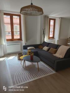 ein Wohnzimmer mit einem blauen Sofa und einem Tisch in der Unterkunft Les 4 vents in Belfort