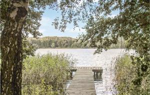 a wooden dock on a lake with a sail boat at Holiday Home Mragowo Sniadowo in Kosewo +11 photos