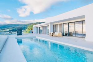 a villa with a swimming pool and a house at Vila Cales e Chadas by Your Madeira Rentals in Arco da Calheta