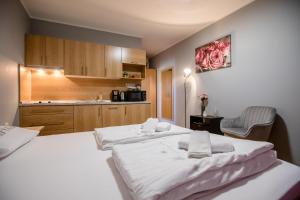 a bedroom with two beds and a kitchen with a sink at Apartmani Ana & Milo in Lopar