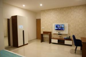 a hotel room with a tv on the wall at Zing Rooms by GuestHouse Suites in Bengaluru