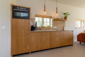 a kitchen with a sink and a counter top at Welcome in - Vakantiewoning - Pioniersweg 3 - Grijpskerke 'De kleine Pionier' in Grijpskerke