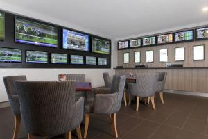 a dining room with tables and chairs and televisions at Shortland Budget Accommodation in Jesmond