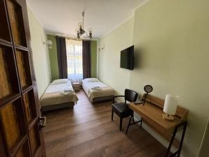 切霍齐内克Willa Zachęta Guesthouse&Coffee的客房设有两张床、一张桌子和一张桌子。