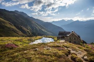une vieille maison sur une colline à côté d'une rivière dans l'établissement Landhaus Sailer, à Kappl