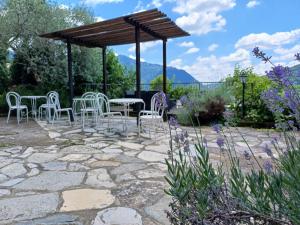 patio z krzesłami i stołami oraz pawilonem w obiekcie Country House Cozzena w mieście Maslianico