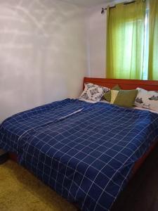 una camera da letto con un letto a quadri blu con una finestra di MEDINA a Sarajevo