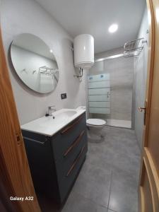 a bathroom with a sink and a toilet and a mirror at Alicante Centro AM in Alicante