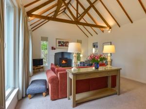 ein Wohnzimmer mit einem roten Sofa und einem Kamin in der Unterkunft Little Barn Cottage in Portloe