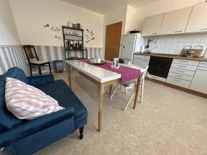 a kitchen with a table and a blue couch at NEU! FeWo bei Hessisch Oldendorf in Hessisch Oldendorf