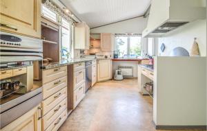 une grande cuisine avec des armoires et des comptoirs en bois dans l'établissement Three-Bedroom Holiday Home In Hemmet, à Hemmet