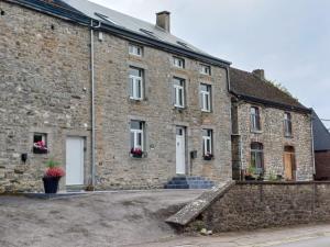 an old brick building with white doors and windows at Gite Mameye in Tellin