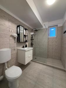a bathroom with a white toilet and a sink at Velvet Breeze Apartment in Năvodari