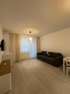 a living room with a couch and a table at Velvet Breeze Apartment in Năvodari