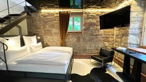 a bedroom with a bed and a desk and a television at Historical Luxury Homes - Luxus Loft Wallstreet in Freiburg im Breisgau