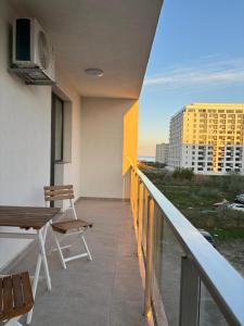a balcony with a table and chairs on a building at Velvet Breeze Apartment in Năvodari