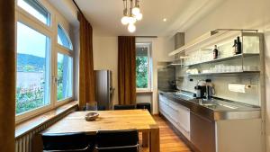 Il comprend une cuisine avec une table en bois et des fenêtres. dans l'établissement Historical Luxury Homes - Luxus Loft Wallstreet, à Fribourg-en-Brisgau
