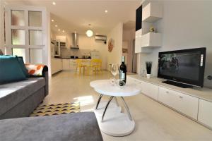 a living room with a couch and a tv and a table at Bungalow Melisa mit Pool in Porec in Poreč