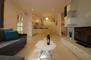 a living room with a couch and a table with a bottle of wine at Bungalow Melisa mit Pool in Porec in Poreč