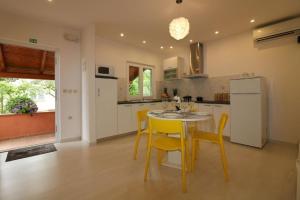a kitchen with a table and chairs and a refrigerator at Bungalow Melisa mit Pool in Porec in Poreč +14 photos