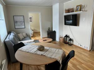 a living room with a table and a couch at WALO APARTMENTS TROMSDALEN - Close to cable car and Arctic Cathedral, 10 min by bus to city centre, Free parking in Tromsø