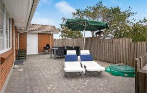 a patio with a table and chairs and an umbrella at Holiday Home Lakolk Rømø Xii in Bolilmark