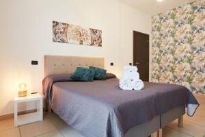 una camera da letto con un letto con due asciugamani sopra di Vicky's Luxury Guesthouse by NapoliApartments a Napoli