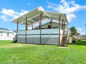 a house with an awning on top of a yard at Beachside at Brooms in Brooms Head