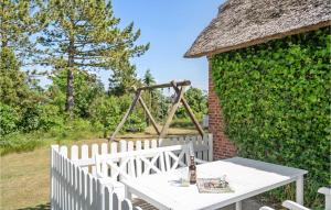 un tavolo bianco e una recinzione con un'altalena di Pet Friendly Home In Rømø With Kitchen a Kongsmark