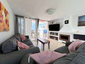 a living room with a couch and a tv at Casa Oda Seaview in Puerto del Carmen