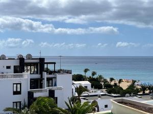 a white building with the ocean in the background at Casa Oda Seaview in Puerto del Carmen