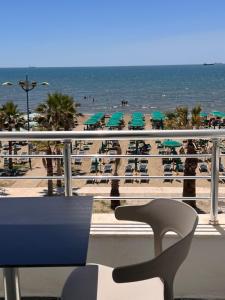 a view of the beach from a balcony with a table and chairs at Wave Beachfront Apartments in Durrës