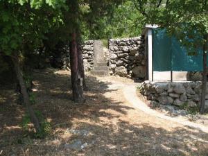 a stone wall next to a tree and a building at Ferienhaus für 6 Personen ca 50 m in Jablanac, Adriaküste Kroatien Kvarner Bucht in Jablanac
