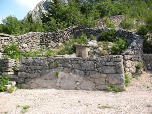 an old stone retaining wall with a stoneolith at Ferienhaus für 6 Personen ca 50 m in Jablanac, Adriaküste Kroatien Kvarner Bucht in Jablanac +13 photos