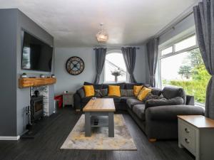 a living room with a couch and a table at Haul a Gwynt in Benllech