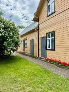 a house with two doors and a grass yard at Sunrise Apartments in Jūrmala