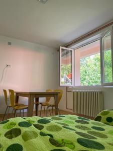 1 dormitorio con mesa, sillas y ventana en Vazdušna Banja Okean Ljubavi, en Soko Banja