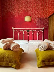 a bedroom with a bed with red walls and towels at Relais San Michele in Rivoli Veronese