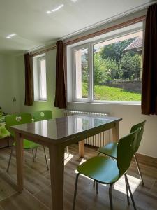 Un comedor con una mesa y sillas verdes. en Vazdušna Banja Okean Ljubavi, en Soko Banja