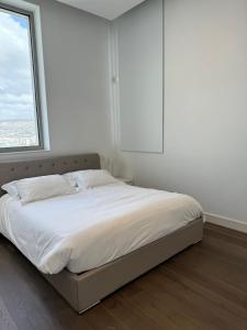 a bed in a white room with a window at Olympic Residence Deluxe Apartments in Limassol