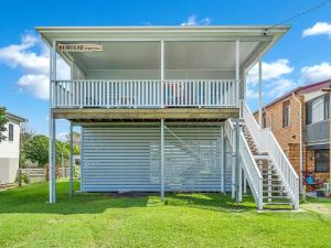 a building with a garage with a stair case at Beachside at Brooms in Brooms Head