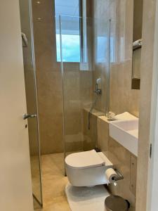 a bathroom with a toilet and a glass shower at Olympic Residence Deluxe Apartments in Limassol