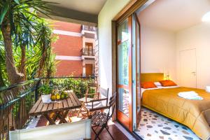 a room with a bed and a balcony with a table at Domus Fuorimura in Sorrento