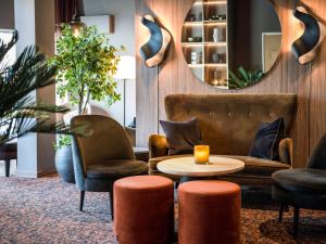 a lobby with two chairs and a table and a mirror at Quality Hotel Saga in Troms&oslash;