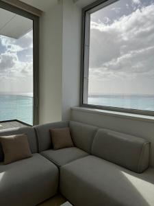 a living room with a couch and a large window at Olympic Residence Deluxe Apartments in Limassol