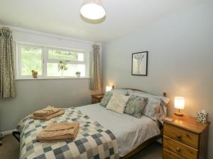 a bedroom with a bed and a window at 9 Manorcombe Bungalows in Callington +22 photos