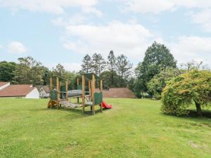a park with two playground equipment in the grass at 9 Manorcombe Bungalows in Callington