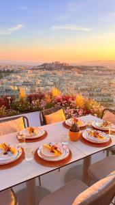 a table with plates of food on it with a view at St George Lycabettus Lifestyle Hotel in Athens