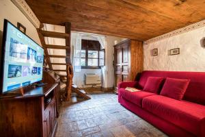 a living room with a red couch and a flat screen tv at La Badia in Sant Arcangelo