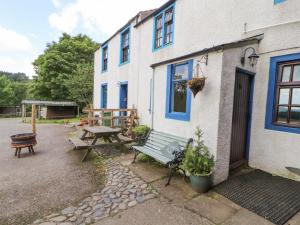 een gebouw met een bank en een picknicktafel buiten bij Kestrel Cottage in Keswick